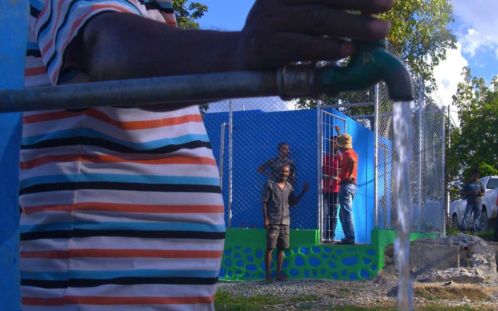 Traballador konstrusaun Abilio de Araujo hatudu hela tanki foun ba bee moos Tokolui nian . Sasan rahun husi tanki tuan nian bele haree iha parte sikun kuana.