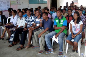 A group of people watch a presentation.