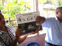 Two men point to a PNDS poster entitled: “What is PNDS?”