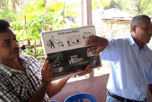 Two men point to a PNDS poster entitled: “What is PNDS?”