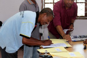 A man signs a form.