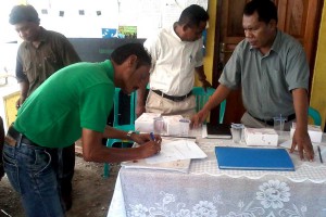 A man signs a form.