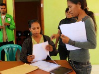 Two women organise papers.