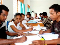 People gathered around a table with pens and paper.
