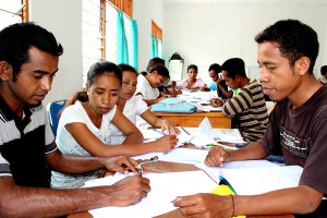 People gathered around a table with pens and paper.