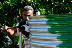 A man adjusts a pipe on a water tank.