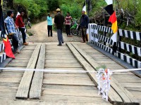 A wooden bridge, decorated with ribbons and flags
