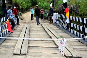 A wooden bridge, decorated with ribbons and flags