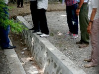 Members of the PNDS community management team in suku Sabuli show the newly completed drainage system to Secretary of State Samuel Mendonça .