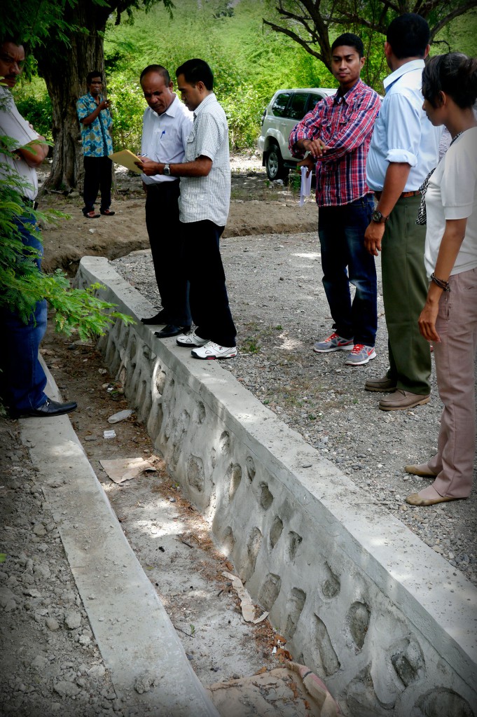 Members of the PNDS community management team in suku Sabuli show the newly completed drainage system to Secretary of State Samuel Mendonça.