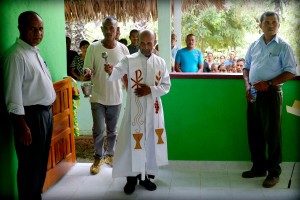Father Deonizio Bere blesses the new community centre in the presence of Secretary of State Mendonca, Metinaro sub-district administrator Fausto Soares Dias, and members of the community.