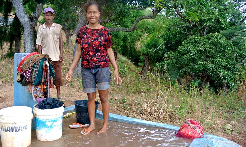 Local woman washing clothes at one of the new water taps.