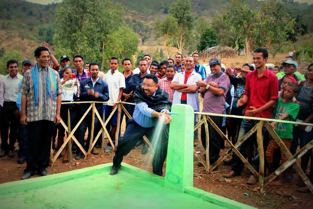 Minister for State Administration Jorge Teme opens a new water tap.