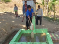 A woman fills a water bottel from the new water tap.