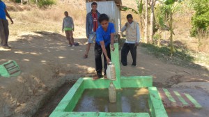 A woman fills a water bottel from the new water tap.