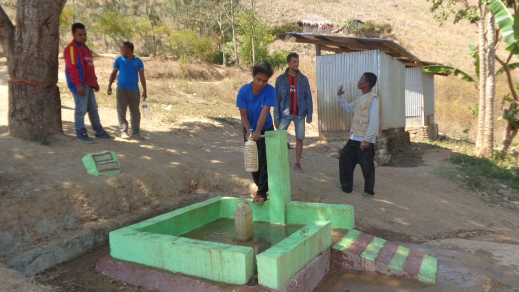 A woman fills a water bottel from the new water tap. 