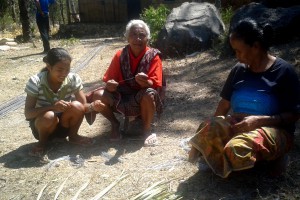Women from suku Abo prepare wire ties to be used in the frame work of their new health clinic 