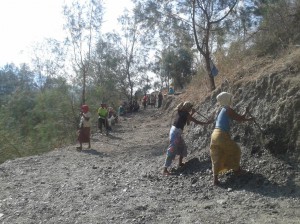 Two women diging on a dirt road