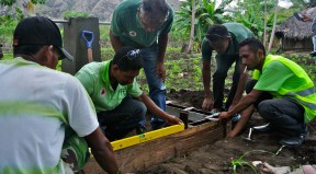 A CNEFP trainer works with a PNDS technical facilitator to check a water tap.